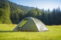 a hiking tent pitched in a grassy clearing
