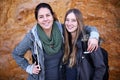 Hiking is their shared passion. Portrait of two attractive young female hikers standing by a rockface.