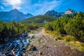 Hiking to mountain lake in National Park High Tatra in autumn and sunny day. Dramatic overcast sky. Zelene pleso, Slovakia, Europe Royalty Free Stock Photo