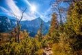 Hiking to mountain lake in National Park High Tatra in autumn and sunny day. Dramatic overcast sky. Zelene pleso, Slovakia. Royalty Free Stock Photo