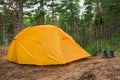 Hiking tourism adventure. Camping picnic blue tent campground in outdoor hiking forest. Touristic boots near camping