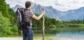 Hiking tourist from behind and lake near Alps in Almsee in Austria. Panoramic photo