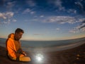 Hiking tourist have a rest in his camp at night near campfire Royalty Free Stock Photo