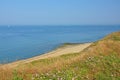 Hiking trail along a field with flowers on the ciffs blue Northe sea coast, Royalty Free Stock Photo