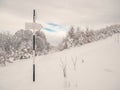 Hiking trail arrow sign at the crossroads. Winter landscape in Carpathian Mountains, Romania