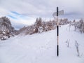 Hiking trail arrow sign at the crossroads. Winter landscape in Carpathian Mountains, Romania