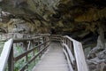 Hiking trail boardwalk under rocky overhang