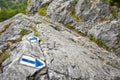 Hiking trail blue paint arrow marking on a rock