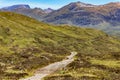 A hiking trail eading towards spectacular mountains with traces of summer snow (Ben Nevis and range, Scotland