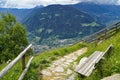 hiking trail over alpine valley of city Merano surrounded by Texel group mountains (Oetztaler Alps, South Tyrol, Italy)