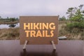 Hiking trail text on card on the swamp background. View of bog with wooden path, small ponds and pine trees. Hiking trail with Royalty Free Stock Photo