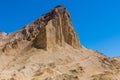 A hiking trail traverses the base of a high desert mountain peak in a vast colorful desert landscape Royalty Free Stock Photo