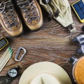 Hiking or travel equipment with boots, compass, binoculars, matches on wooden background. Active lifestyle concept. Royalty Free Stock Photo