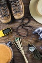 Hiking or travel equipment with boots, compass, binoculars, matches on wooden background. Active lifestyle concept. Royalty Free Stock Photo