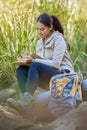 Hiking, travel and woman writing in book sitting outdoors in nature. Freedom, hiker and happy female from India with Royalty Free Stock Photo