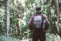 A hiking traveler standing with a backpack and a hat, traveller, hipster looking in the woods. Concept of adventures traveling Royalty Free Stock Photo