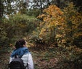 Hiking woman at autumn forest. Backpacker standing in woodland during fall season. Enjoying hike in nature at sunny day Royalty Free Stock Photo