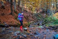 Hiking woman with backpack crosses the stream Royalty Free Stock Photo