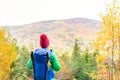 Hiking woman with backpack looking at inspirational autumn golden woods Royalty Free Stock Photo