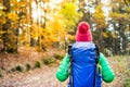 Hiking woman with backpack looking at inspirational autumn golden woods Royalty Free Stock Photo