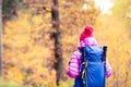 Hiking woman with backpack looking at inspirational autumn golden woods Royalty Free Stock Photo