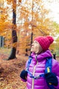 Hiking woman with backpack looking up at inspiring autumn trees Royalty Free Stock Photo