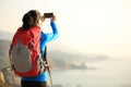 Hiking woman use smart phone taking photo Royalty Free Stock Photo