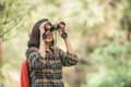 Hiking women use binoculars to travel and have a happy smile. tourist looking through binoculars considers wild birds in the Royalty Free Stock Photo