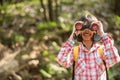 Hiking women use binoculars to travel and have a happy smile. tourist looking through binoculars considers wild birds in the Royalty Free Stock Photo