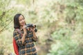 Hiking women use binoculars to travel and have a happy smile. tourist looking through binoculars considers wild birds in the Royalty Free Stock Photo