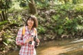 Hiking women use binoculars to travel and have a happy smile. tourist looking through binoculars considers wild birds in the Royalty Free Stock Photo