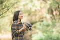 Hiking women use binoculars to travel and have a happy smile. tourist looking through binoculars considers wild birds in the Royalty Free Stock Photo