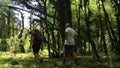 Hiking young woman and two boys walking together on the trail with backpack. Creative. Green beautiful vegetation and Royalty Free Stock Photo