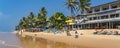 Narigama beach at Hikkaduwa with people on sunbeds and small restaurants in background