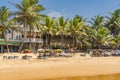 Narigama beach at Hikkaduwa with people on sunbeds and small restaurants in background