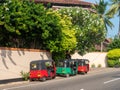 Hikkaduwa, Sri Lanka - March 4, 2022: Bright multi-colored tuk-tuks, Sri Lankan vehicles, stand outside the hotel under the trees