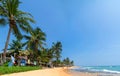 Sunny Beach on Indian Ocean. Palm trees on sandy shore. People on coast