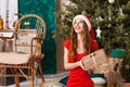 Hilarious Christmas Woman Wearing Santa Hat Sitting And Holding A Gift Royalty Free Stock Photo
