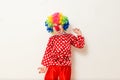 Hilarious five-year-old boy dances in clown costume and wig on white background Royalty Free Stock Photo