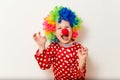 Hilarious five-year-old boy dances in clown costume and wig on white background Royalty Free Stock Photo