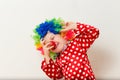 Hilarious five-year-old boy dances in clown costume and wig on white background Royalty Free Stock Photo