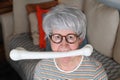 Hilarious senior woman holding bone with mouth