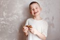 Hilarious smiling seven-year-old child with pancakes in his hands