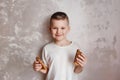 Hilarious smiling seven-year-old child with pancakes in his hands