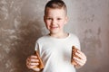 Hilarious smiling seven-year-old child with pancakes in his hands