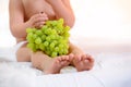 ?hild`s legs grapes on a white background eat.