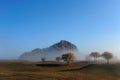 Hill and autumn trees in a foggy morning Royalty Free Stock Photo