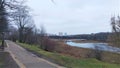 On a hill in the city park among the trees is a tiled walkway with benches and lanterns. From above, there is a view of the river Royalty Free Stock Photo