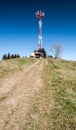 Hill with communication tower, small wooden view tower, big stone and clear sky