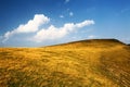 Hill with dry yellow grass and blue sky Royalty Free Stock Photo